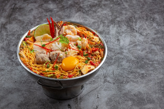 Thai Essen. Nudeln würzig kochen mit Meeresfrüchten und Schweinefleisch im heißen Topf