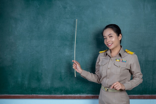 thailändischer Lehrer im offiziellen Outfit, der vor der Tafel unterrichtet