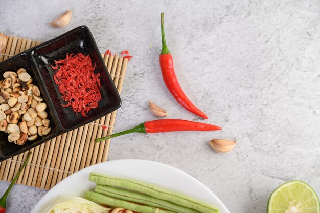 Thailändischer Papayasalat in einer weißen Platte mit Paprika, Kalk und Knoblauch.