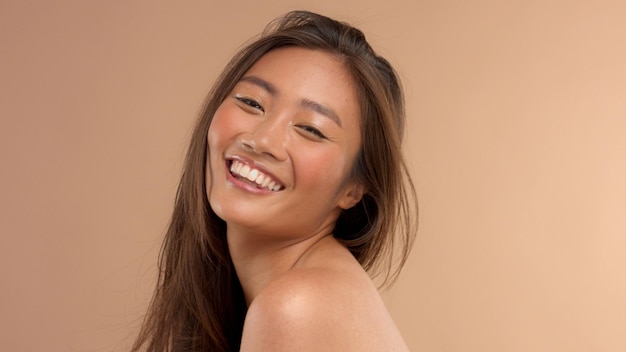 Thailändisches asiatisches Modell mit natürlichem Make-up auf beigem Hintergrund