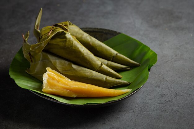 Thailändisches Dessert. Gedämpftes Cantaloupe-Gebäck in Bananenblattkegel gewickelt