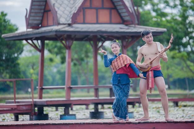 Thailand Frauen und Mann in Tracht mit Gitarrennadel (Zupfinstrument)