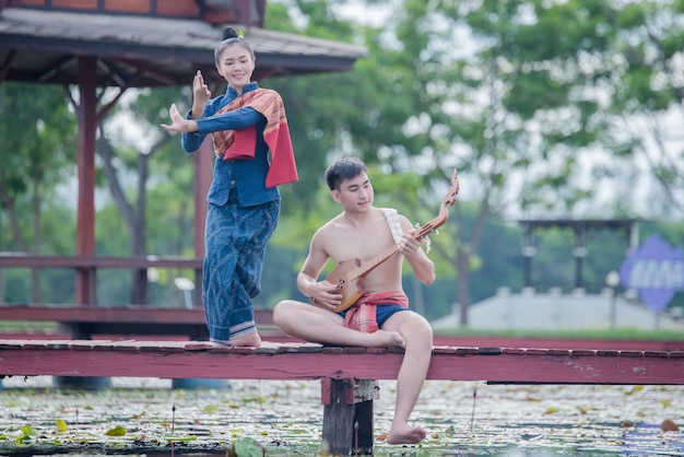 Thailand Frauen und Mann in Tracht mit Gitarrennadel (Zupfinstrument)