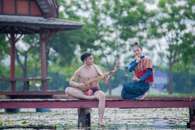 Thailand Frauen und Mann in Tracht mit Gitarrennadel (Zupfinstrument)
