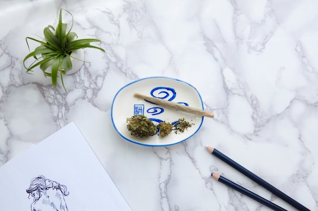 THC CBD Marihuana Joint und Blumen auf Aschenbecher mit Aktillustration auf Zeichenblock