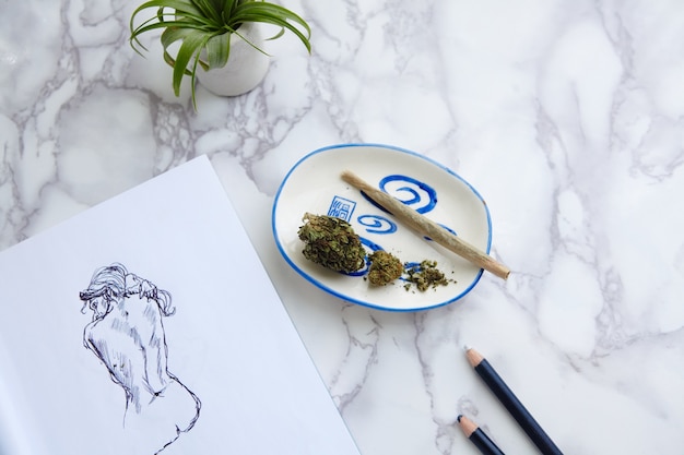 THC CBD Marihuana Joint und Blumen auf Aschenbecher mit Aktillustration auf Zeichenblock