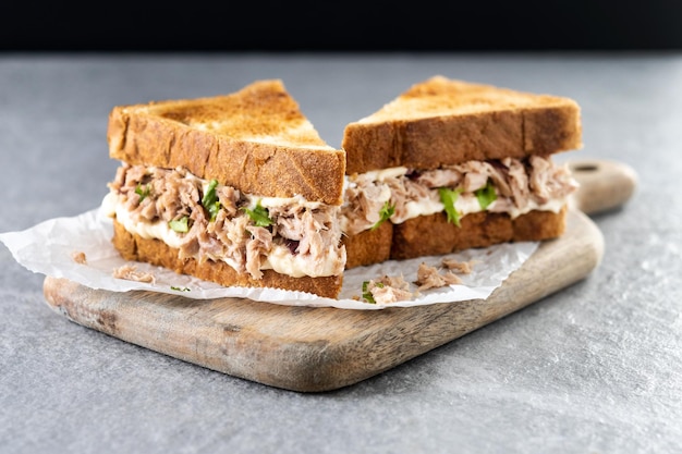 Thunfisch-Sandwich mit Mayonnaise und Gemüse auf grauem Steinhintergrund