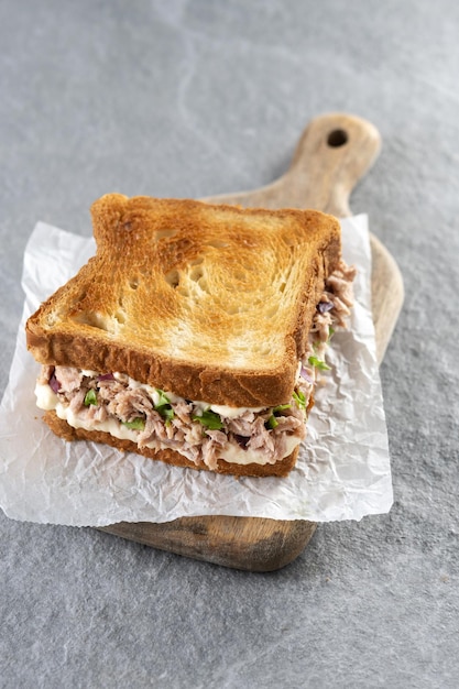 Thunfisch-Sandwich mit Mayonnaise und Gemüse auf grauem Steinhintergrund