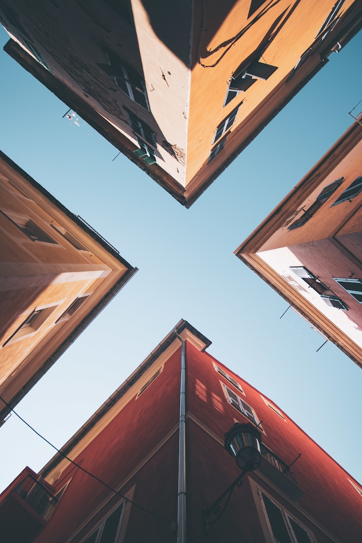 Kostenlose Foto tiefwinklige aufnahme von vier gebäuden unter dem blauen himmel
