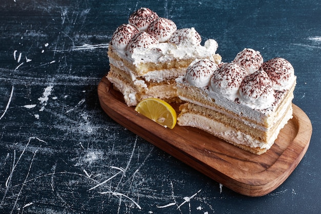 Tiramisu-Kuchenstücke in einer Holzplatte.