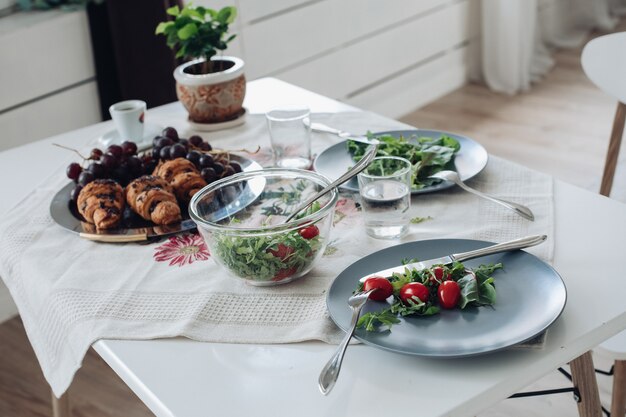 Tisch mit gesundem, leckerem Frühstück, umgeben von modernem Interieur am Sommermorgen