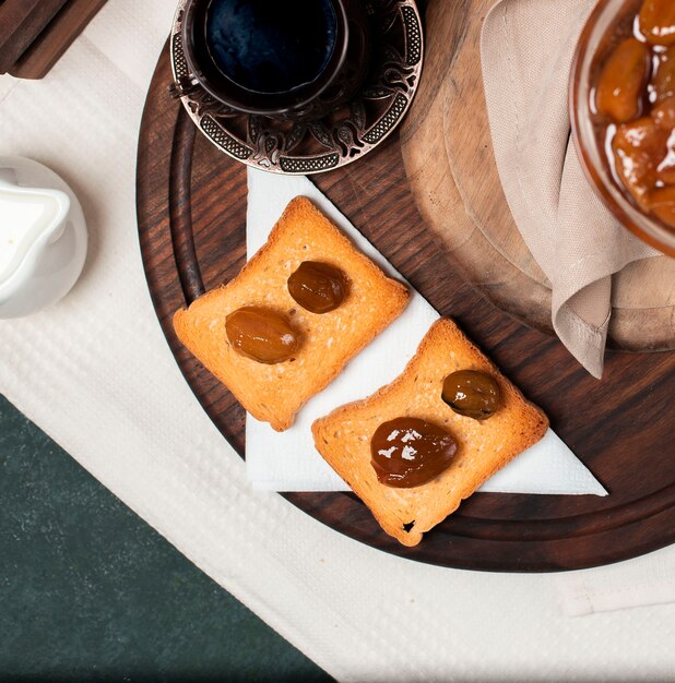 Toast mit Feigenkonfitüre und einem Glas schwarzem Tee.