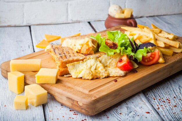 Toast mit Käse und Tomaten und Pommes in Teller