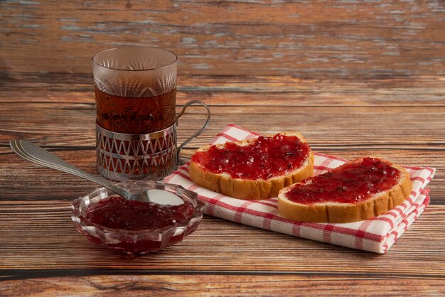 Toast mit Pflaumenkonfitüre und einem Glas Tee.