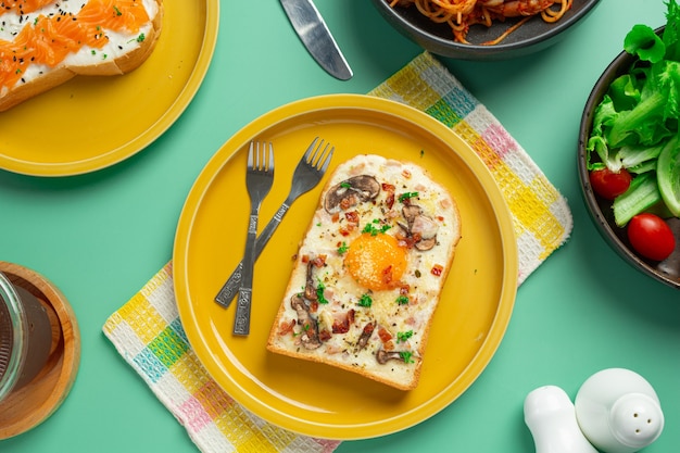 Toast mit Spiegelei und Frischkäse auf pastellgrünem Hintergrund