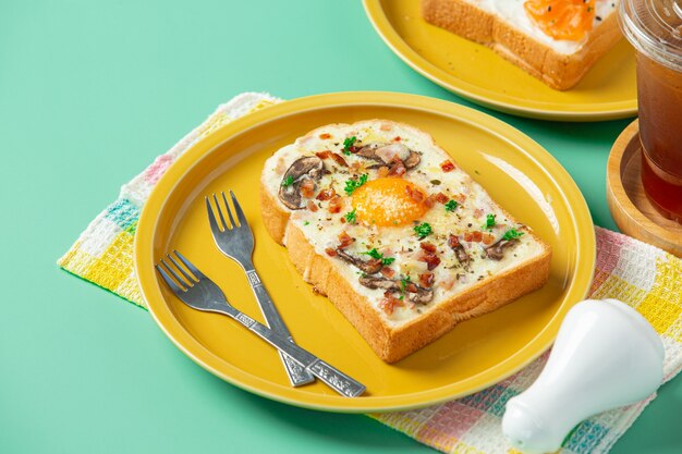 Toast mit Spiegelei und Frischkäse auf pastellgrünem Hintergrund