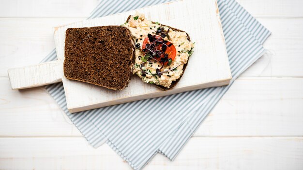 Toastbrot mit Gemüse Nudeln und Tomaten auf Holzbrett