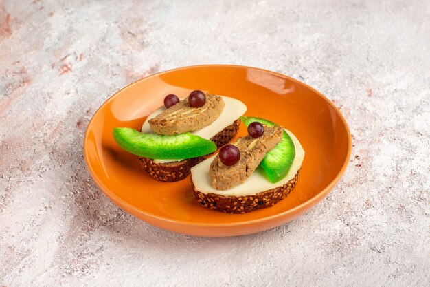 Toastbrot Toast mit Pasteten- und Gurkenscheiben in der orangefarbenen Platte auf weißer Oberfläche