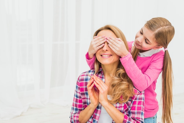 Tochter, die augen der mutter bedeckt