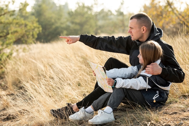 Kostenloses Foto tochter, die eine karte und einen vater zeigen die richtung hält