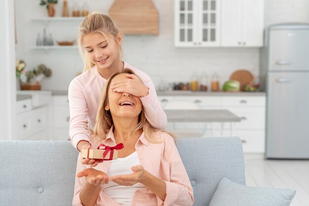 Tochter, die ihrer Mutter ein Geschenk anbietet