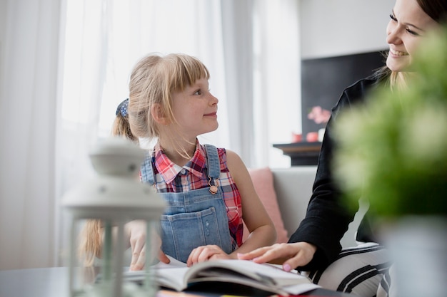 Tochter, die Mutter beim Studieren betrachtet