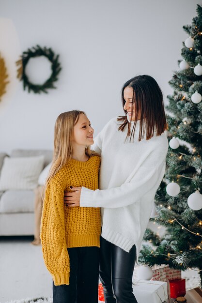 Tochter mit Mutter am Weihnachtsbaum