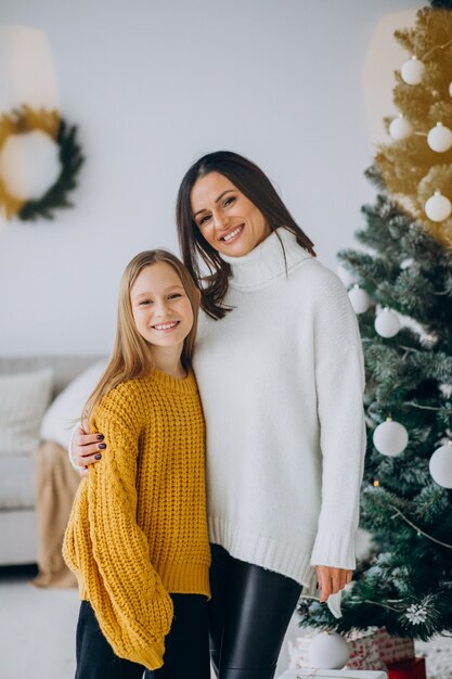 Tochter mit Mutter am Weihnachtsbaum