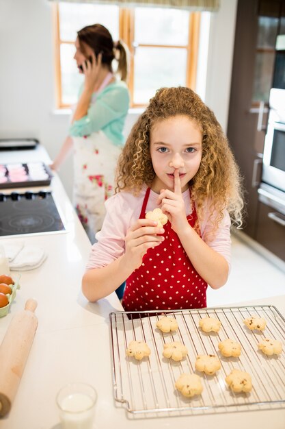 Tochter nehmen Cookies heimlich während Mutter sprechen auf Handy