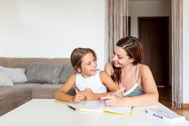 Tochter und Mutter machen gemeinsam Hausaufgaben