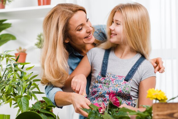 Tochter und Mutter pflanzen Blumen