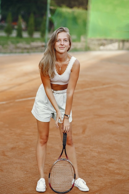 Toller Tag zum Spielen! Fröhliche junge Frau im T-Shirt. Frau, die Tennisschläger und Ball hält.