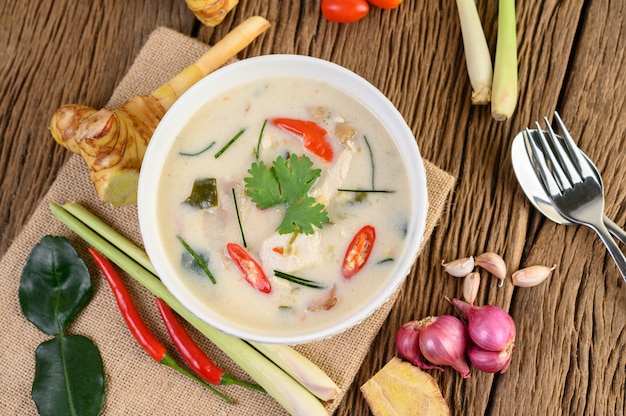 Kostenloses Foto tom kha kai in einer schüssel mit kaffirlimettenblättern, zitronengras, roten zwiebeln, galangal und chili.