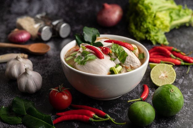 Tom Yum Huhn mit Chili, Koriander, getrocknetem Chili, Kaffirlimettenblättern, Pilzen und Zitronengras in einer Schüssel