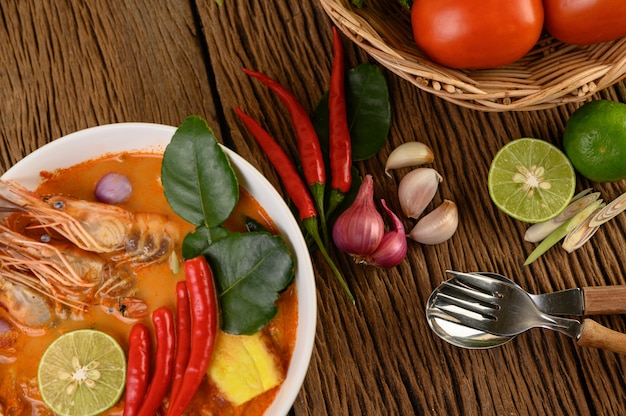 Tom Yum Kung Thailändische scharfe Suppengarnele mit Zitronengras, Zitrone, Galangal und Chili auf Holztisch, Thailand Food