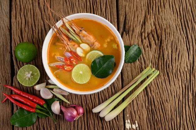 Tom Yum Kung Thailändische scharfe Suppengarnele mit Zitronengras, Zitrone, Galangal und Chili auf Holztisch, Thailand Food