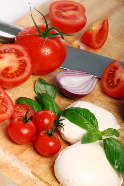 Tomaten, Basilikum und Mozzarella auf Holzbrett