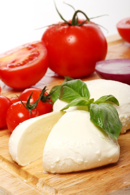 Tomaten, Basilikum und Mozzarella auf Holzbrett