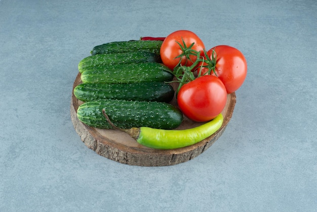 Tomaten, Gurken und Pfeffer auf Holzstück.