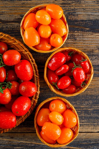 Tomaten in Weidenkörben auf einem Holztisch. Draufsicht.