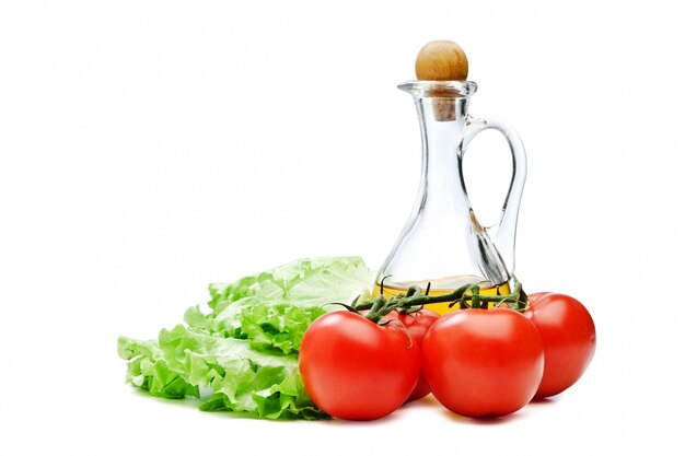 Tomaten-, salatsalat und krug pflanzenöl lokalisiert auf dem weißen hintergrund