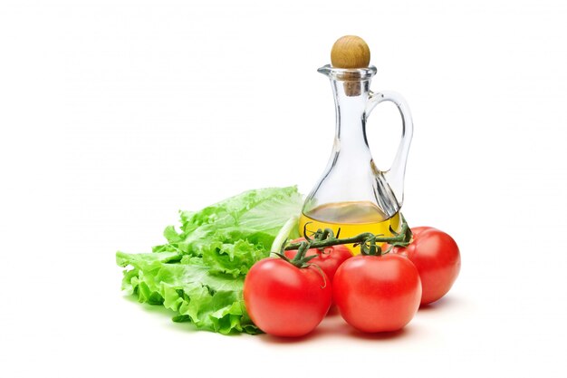 Tomaten-, salatsalat und krug pflanzenölöl lokalisiert auf dem weißen hintergrund