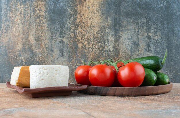 Tomaten und Gurken mit Käse auf Marmor