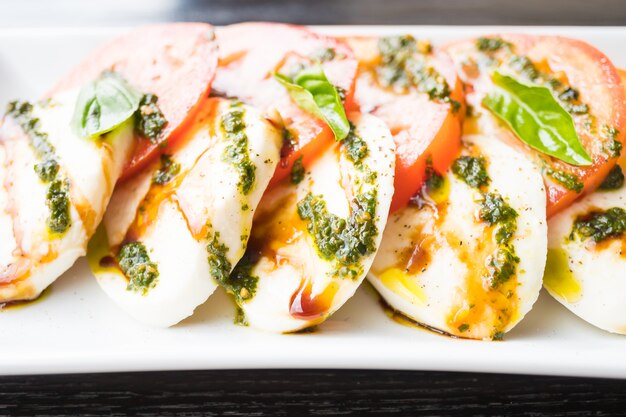 Tomaten- und Mozzarellakäsesalat in der weißen Platte