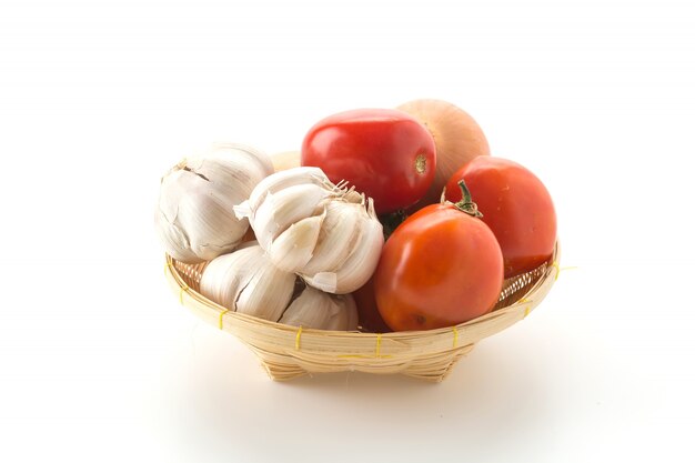 Tomaten, zwiebeln und knoblauch im korb