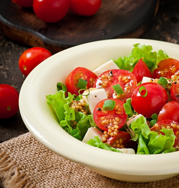 Kostenloses Foto tomatensalat mit salat, käse und senf-knoblauch-dressing