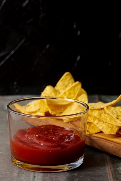 Tomatensauce auf glasschüssel und nachos