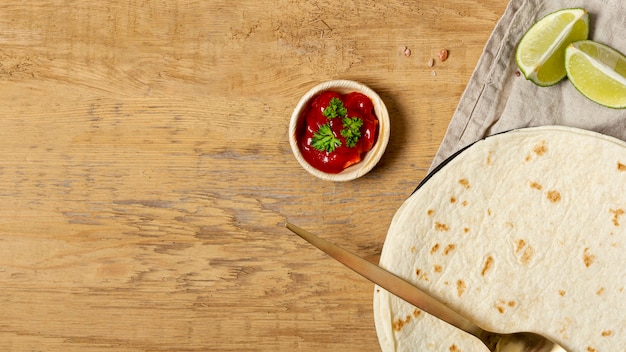 Kostenloses Foto tomatensauce nahe löffel und tortilla mit geschnittenem kalk