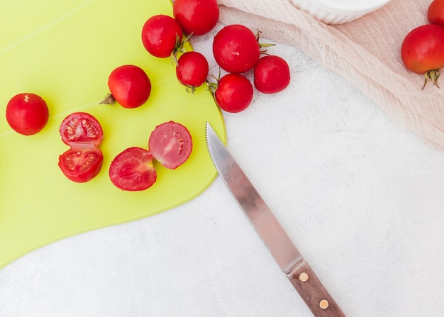 Tomatenscheiben auf Schneidebrett mit scharfem Messer