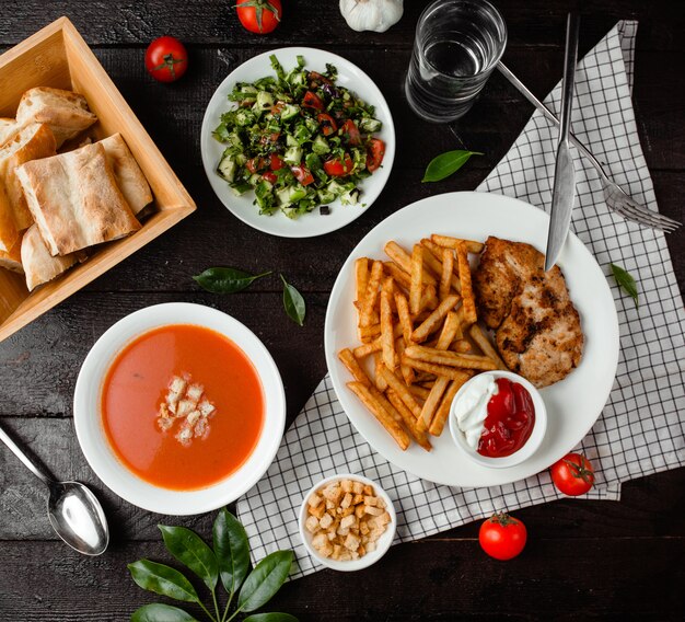 Tomatensuppe, Gemüsesalat und Hühnchen mit Pommes Frites